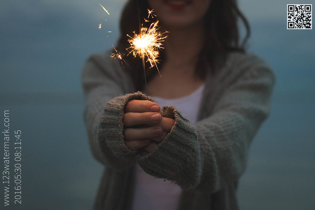 Watermarked image of women with sparkler in hand with QR and side watermark text.